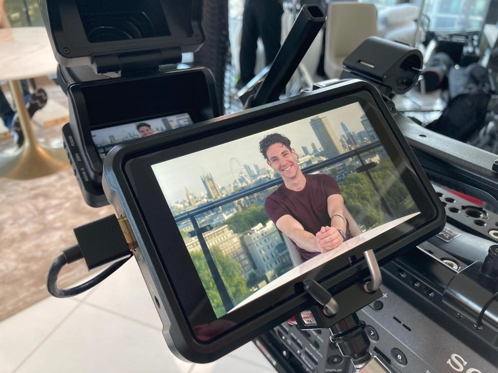 Film Industry Apprentice photo showing a young man being viewed on a professional video monitor as part of a film shoot. He's smiling like a loon.