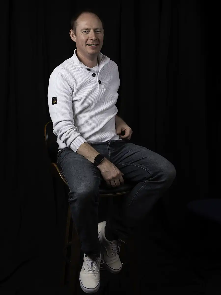 A portrait style photo of a particularly handsome man sitting on a chair. He looks very casual in jeans and a jumper. He's the MD of Vermillion Films and obviously he wrote this himself.