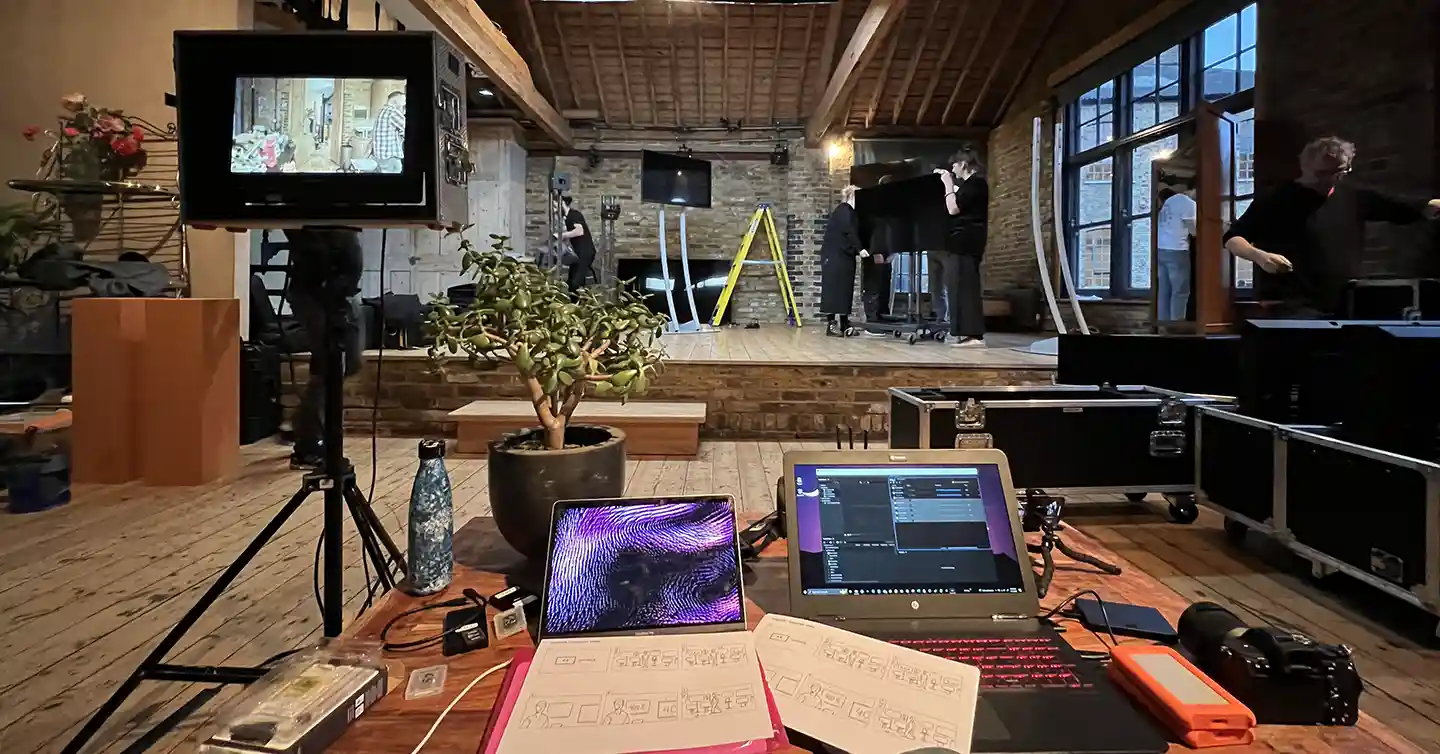 Image from a startup video production for tech startup Yodeck. features a laptop, storyboards and monitor and people working in the background.
