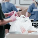 Engaging Video by Vermillion Films. A photo of people filling bags at a food bank in Birmingham