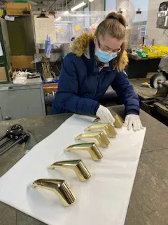 A young woman arranging a series of gold taps in preparation for a product shoot by Vermillion Films Video Production Birmingham