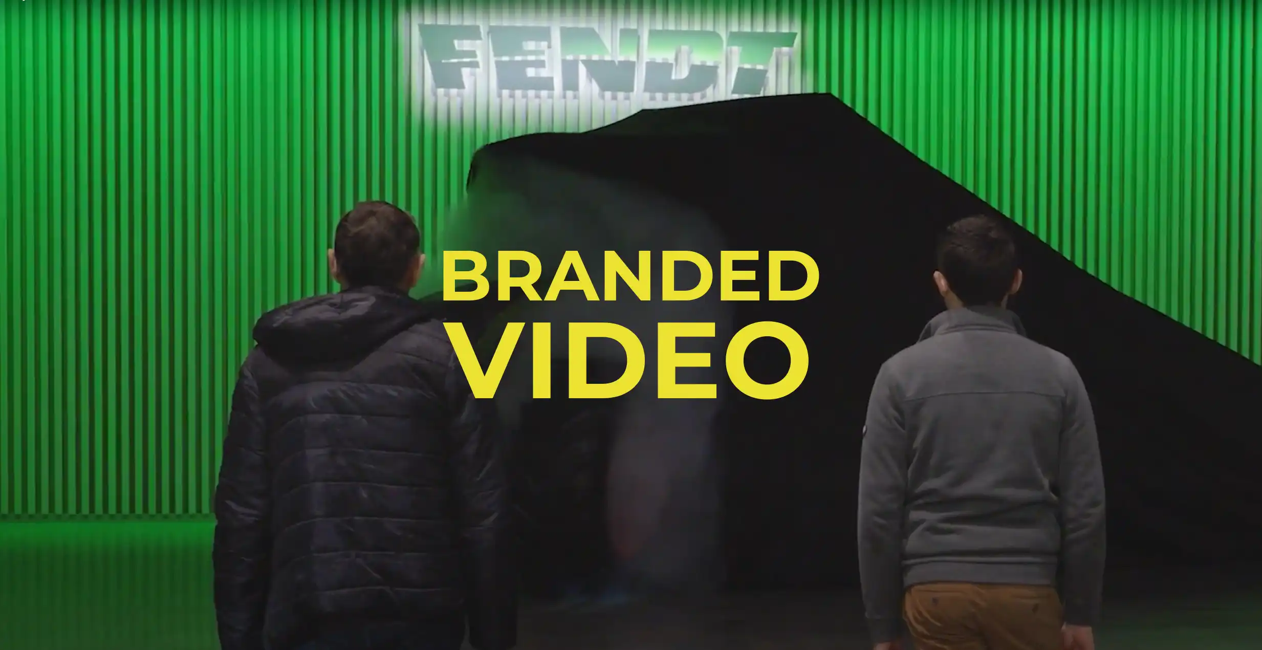 Branded video production featured image features two men watching a refurbished tractor about to be revealed